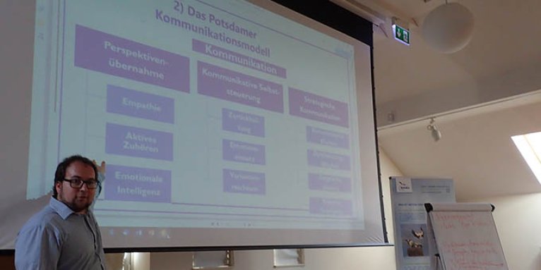 Trainer Dr. Moritz Kirchner erläutert das Potsdamer Kommunikationsmodell – Foto: Laura Klein